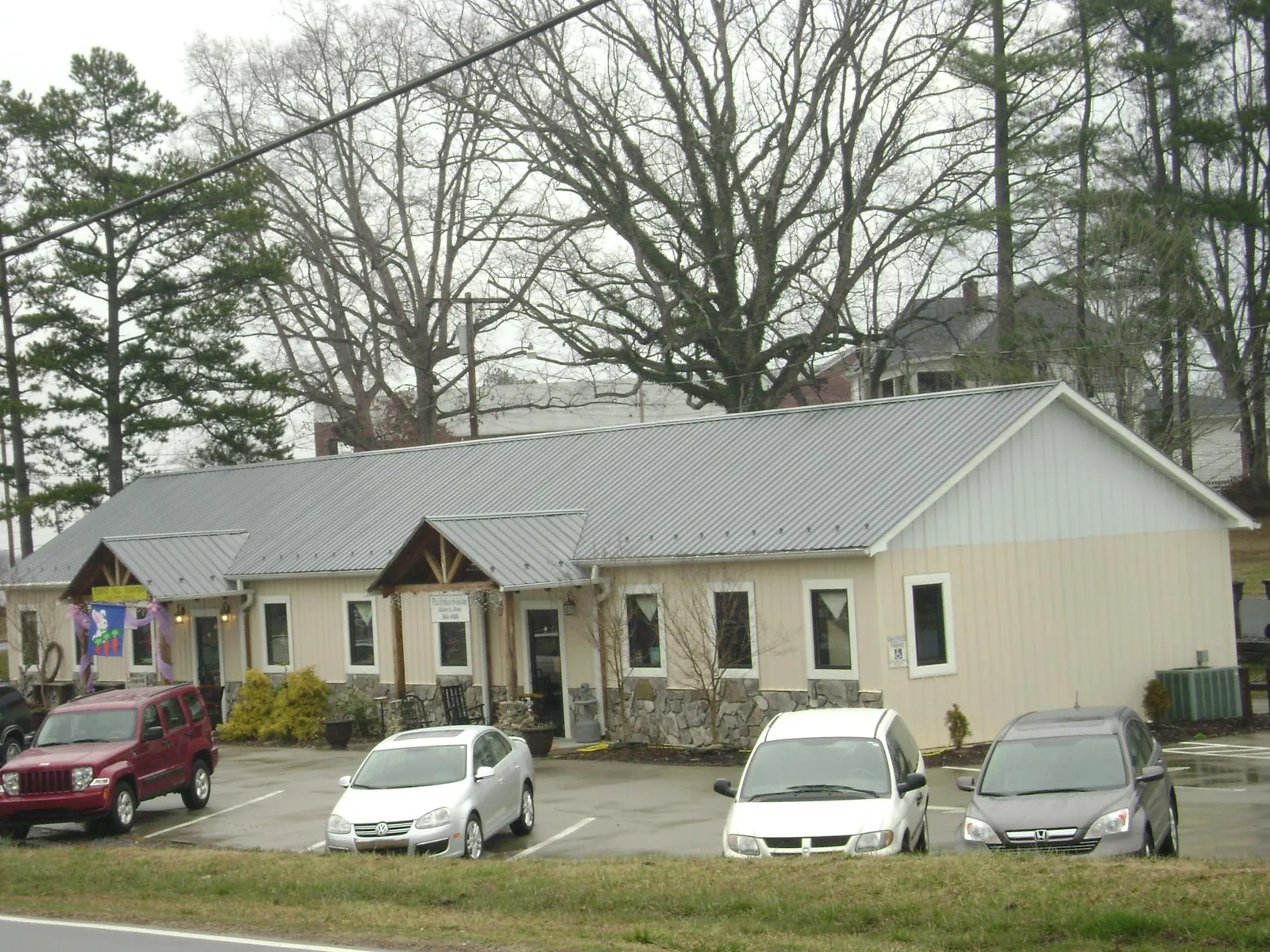 Gray metal roof with timber entry brackets on a small commercial building in Newark