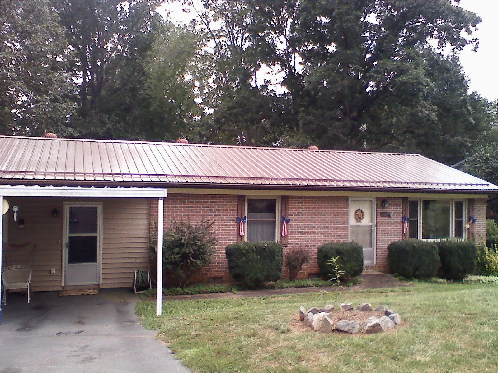 Bronze metal roof and carport on a brick ranch home — Roof Repair work by our crew in Newark